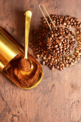 Wall Mural - Coffee beans, golden cup of coffee on a brown background.