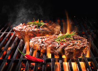 Beef steaks sizzling on the grill