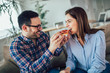 Beautiful young couple eating pizza,talking and smiling at home.