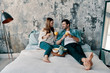 © gstockstudio - Enjoying time together. Beautiful young couple having breakfast while spending time in bed at home