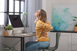 © New Africa - Young woman suffering from back pain in office