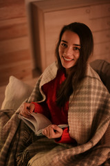 Sticker - Woman with plaid reading book at home. Winter season