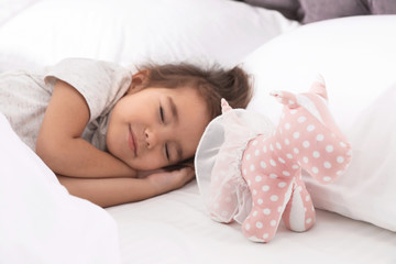 Wall Mural - Cute little girl with toy sleeping in bed