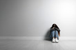 © New Africa - Upset teenage girl sitting on floor near wall. Space for text