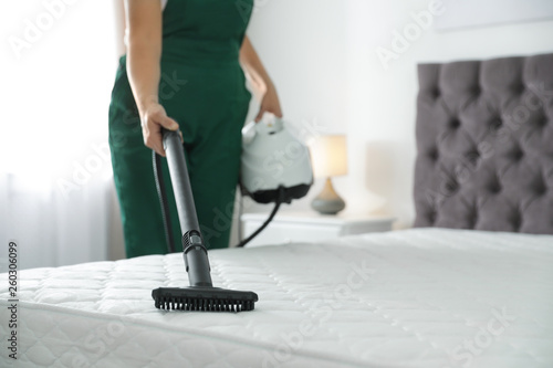 Cuadros en Lienzo Janitor cleaning mattress with professional equipment in bedroom, closeup