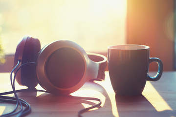 coffee cup and earphones on wooden table