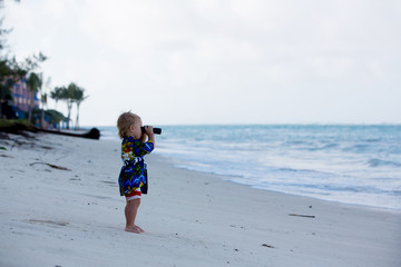 Canvas Print - Mom, holding little toddler boy with binoculars, observing dolphins