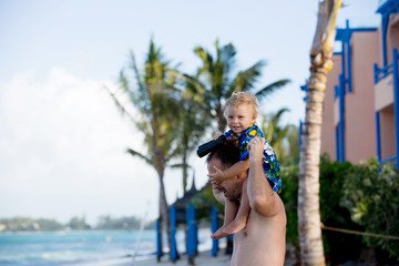 Canvas Print - Dad, holding little toddler boy with binoculars, observing dolphins