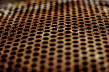 Wall Mural - Perforated brown rusty iron sheet texture. Surface with depth of field, abstract mesh. Horizontal grunge background