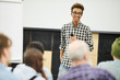 © Seventyfour - Positive successful young African-American entrepreneur in glasses standing in front of audience and laughing while talking to people at business conference