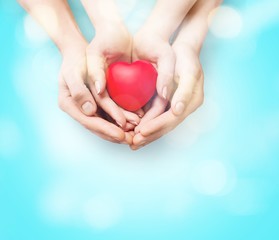 Poster - Man and woman holding red heart in hands isolated on white