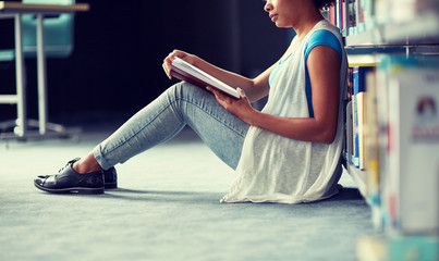 Canvas Print - education, high school, university, learning and people concept - happy smiling african american student girl reading book at library