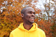 © mimagephotos - Close up handsome young african american man smiling against autumn leaves in background