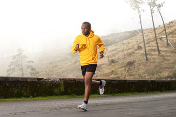 Wall Mural - Full length side of healthy young african american man running on street