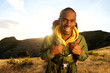 © mimagephotos - happy african american man hiking in mountains with backpack and sunset in background