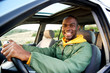 © mimagephotos - smiling young african american man driving car