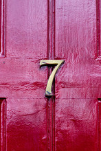 House Number Seven With The 7 In Brass On A Burgundy Red Front Door