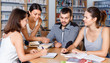 © JackF - Happy young university students preparing for exam together, brainstorming in library