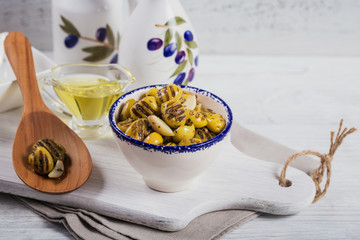 Wall Mural - Grilled olives with garlic, olive oil and spices on white rustic table