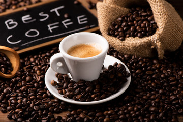 Cup of coffee surrounded by coffee beans