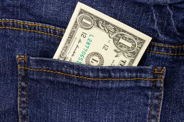 One dollar bill in a pocket of blue jeans