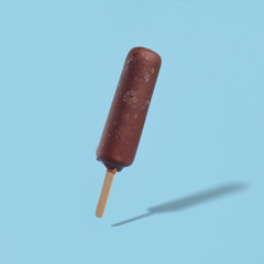 Wall Mural - chocolate covered popsicle ice cream on a blue background