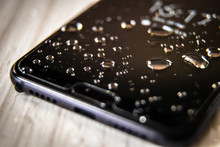 Front Side Of Waterproof Smartphone Covered With Drops Of Water