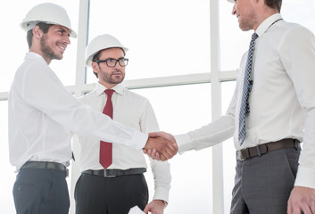 Wall Mural - Two architects shaking hands after a meeting in office