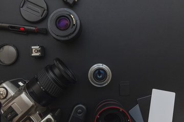 Canvas Print - Photographer workplace with dslr camera system, camera cleaning kit, lens and camera accessory on dark black table background. Hobby travel photography concept. Flat lay top view copy space