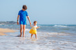 © levranii - Kids playing on tropical beach. Big brother together with his little sister at sea shore at sunset. Family summer vacation. Children play with water. Ocean and island fun