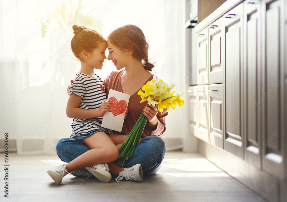 happy mother's day! child daughter   gives mother a bouquet of flowers to narcissus and gift. - obrazy, fototapety, plakaty 