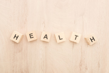 Wall Mural - top view of cubes with health lettering on wooden background