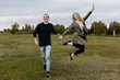 © MeganMahoneyPhotos - Young Couple in Love Running in a Big Open Outdoor Field in the Spring Holding Hands and Laughing