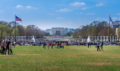 Wall Mural - People walking toward the crowd in front of the Lincoln memorial and reflection pool in Washington DC USA on a sunny spring morning