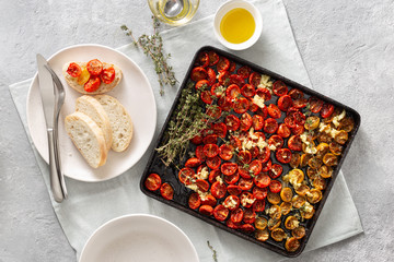 Canvas Print - Baked juicy cherry tomatoes into baking tray on concrete background top view