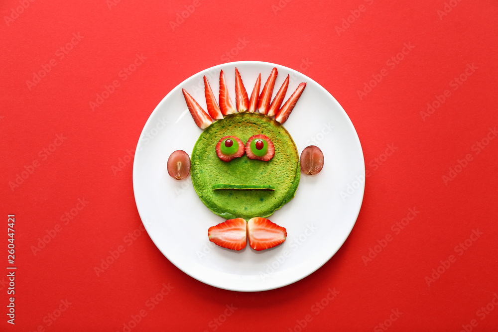 Plate with tasty green pancake for kid on color background