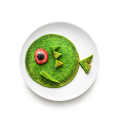 Plate with tasty green pancake for kid on white background