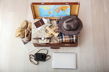 Canvas Print - Open packed suitcase on floor. Travel concept