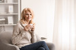 © Pixel-Shot - Stylish mature woman drinking coffee at home