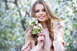 © darkfreya - Beautiful girl in blossom cherry garden. Gardening.