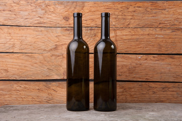 two wine bottles of wine on wooden background