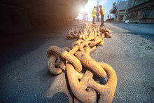 Anchor Chains Bundle Laying At Bottom Layer Of The Ship In Floating Dry Dock, For Recondition Maintenance With Sand Blasting Perform, Port Control And Inspector Surveying Condition In Background