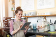© pikselstock - Young woman using digital tablet in coffee shop