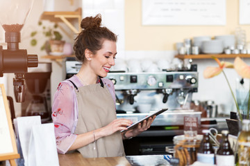 Wall Mural - young woman using digital tablet in coffee shop