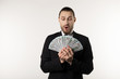 © Vasya - Portrait of surprised handsome businessman wearing black suit showing money banknotes