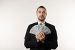 © Vasya - Portrait of surprised handsome businessman wearing black suit showing money banknotes