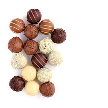 Top View Of Various Chocolate Pralines Isolated On White Background. Space For Your Text