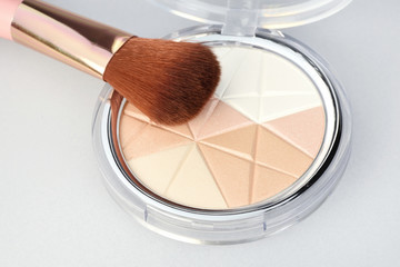 Close-up of makeup brush with mineral shimmer palette. Beauty concept.