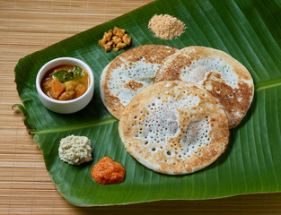 Kerala traditional tattu dosa served on a banana leaf along with sambar and chatni