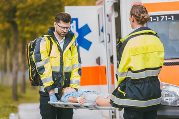 Canvas Print - Medics putting injured boy on stretcher after accident